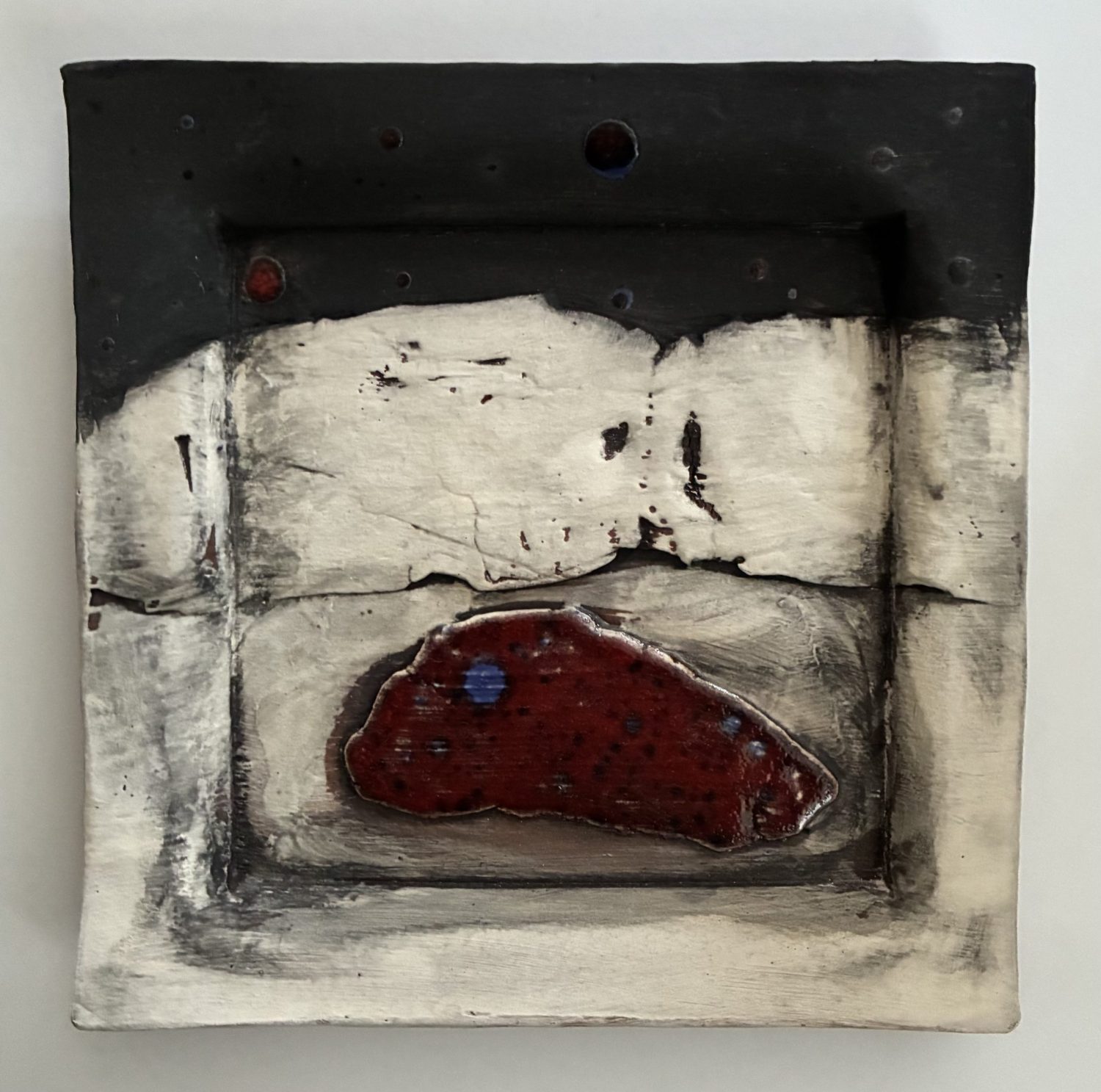 Square shaped ceramic landscape with black and red glazes